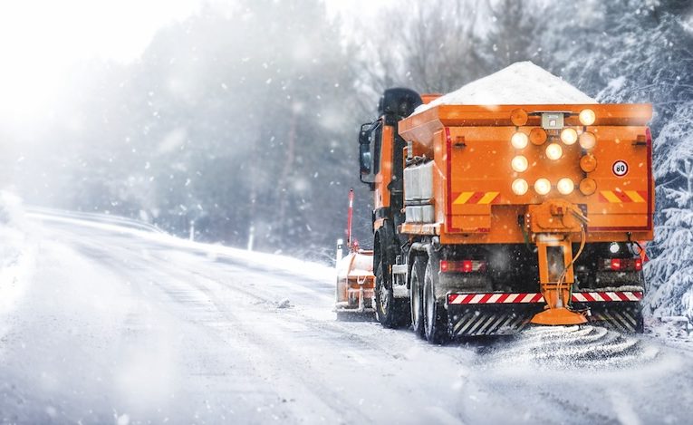 Sypač na zasněžené silnici