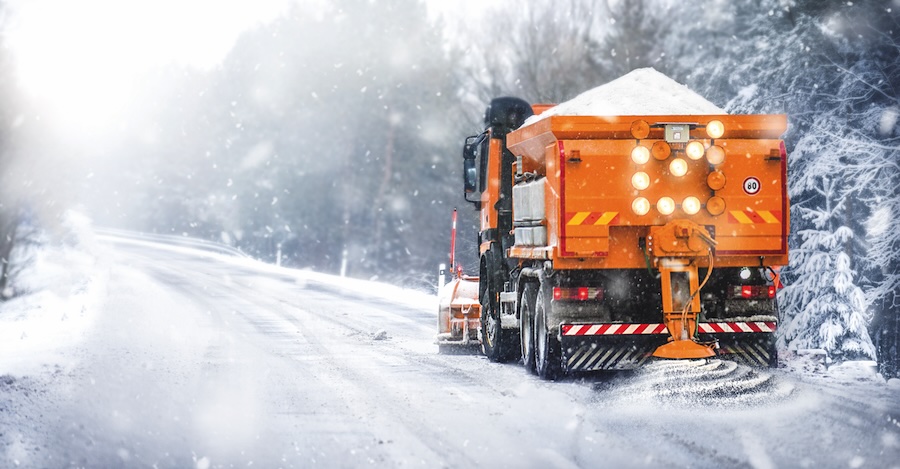 Sypač na zasněžené silnici
