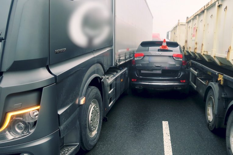 Auto zaseklé mezi náklaďáky
